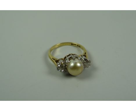 AN 18k YELLOW GOLD RING SET with a pair of round cut diamonds & a raised centre pearl, 4.8gms