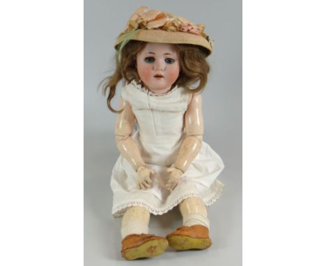 A MAX HANDWERCK BEBE ELITE BISQUE HEAD DOLL having weighted brown glass eyes, open mouth with upper teeth & wig on a fully jo