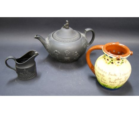 Wedgwood, a large basaltes teapot, bisque finished with relief decoration and a glazed interior. Together with a similar milk