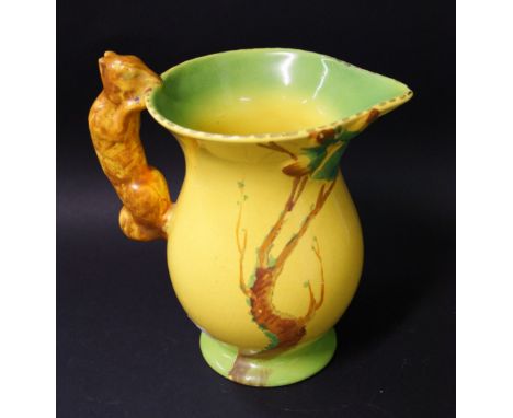 Burleighware, a ceramic pitcher with a moulded grip in the form of a squirrel. The body painted against a two-tone ground. 