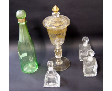 An emerald green glass decanter with stopper with silver collar, together with three glass bottles with stoppers and and a gi