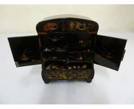 Oriental lacquered curio cabinet of rectangular form on bracket feet, the inside drawers revealing various curios