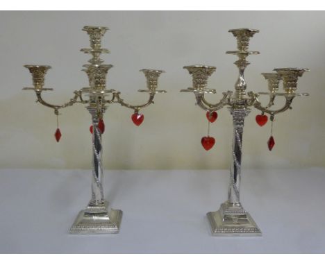 A pair of Victorian silver five light candelabra, the Corinthian column stems with spiral husk and leaf decoration on raised 