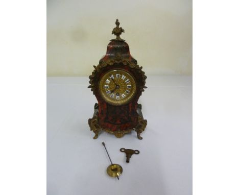 A French boule mantle clock, gilt metal and enamel dial with Roman numerals to include key and pendulum