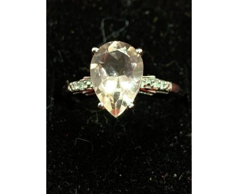 A 9 CARAT WHITE GOLD RING WITH A LARGE PALE PINK STONE AND DIAMOND CHIPS ON THE SHOULDER J/K 