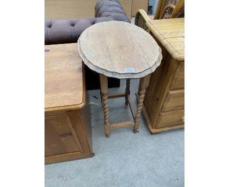 A SMALL OAK OCCASIONAL TABLE WITH PIE CRUST EDGE AND BARLEY TWIST SUPPORTS 