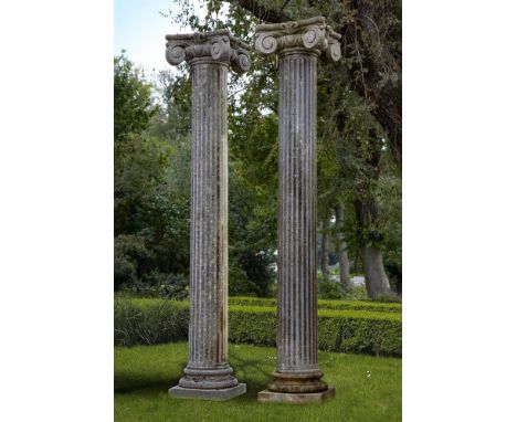 A pair of Continental limestone columns, 20th century, each carved with an Ionic voluted capital above a fluted shaft, waiste