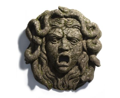 A carved limestone wall fountain, in the form of the head of Medusa, 20th century, modelled with mouth agape as the aperture,