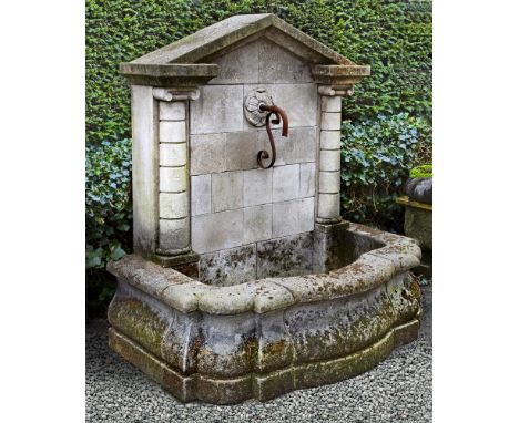 A monumental wall fountain, of architectural form, 20th century, the pediment above an ashlar block back and flanking pilaste