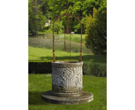 A Continental sculpted limestone and wrought iron mounted well head, 20th century, of cylindrical form, the projecting rim ab