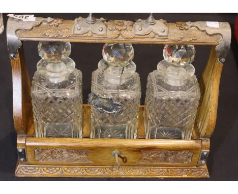 Victorian three decanter oak tantalus with good relief carving. P&amp;P Group 3 (£25+VAT for the first lot and £5+VAT for sub