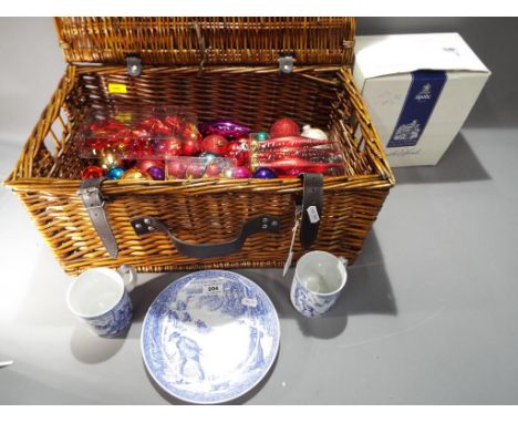 A good quality wicker picnic basket containing a large quantity of Christmas baubles and decorations, also included in the lo
