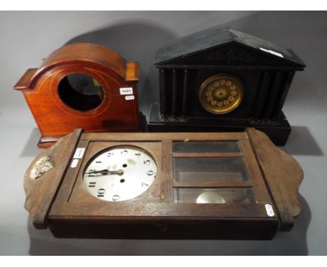A slate cased mantle clock [lacking hands], a further mantle clock case and a German wall clock.[3]