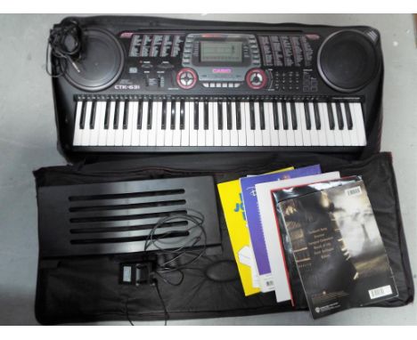 A Casio CTK-631 electronic keyboard with music books, contained in a carry case.