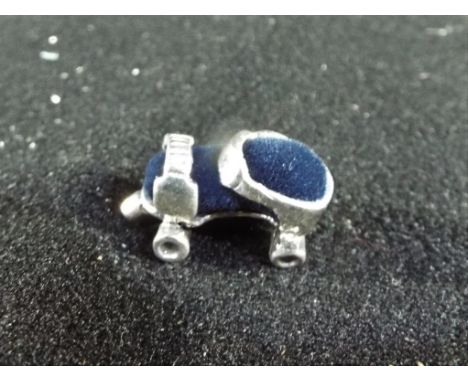 A silver miniature pin cushion in the style of a Roller Skate