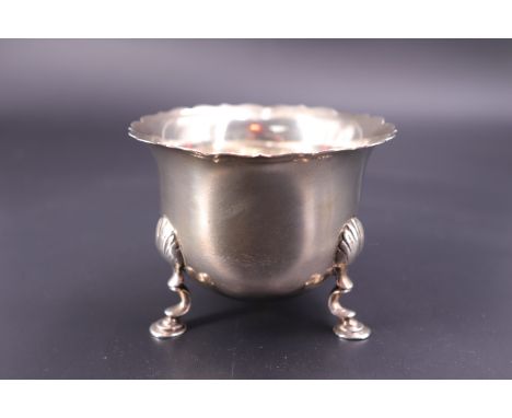 A late Victorian silver sugar basin, having a cusped everted rim and three shell-hipped Georgian style legs, sponsor's mark i