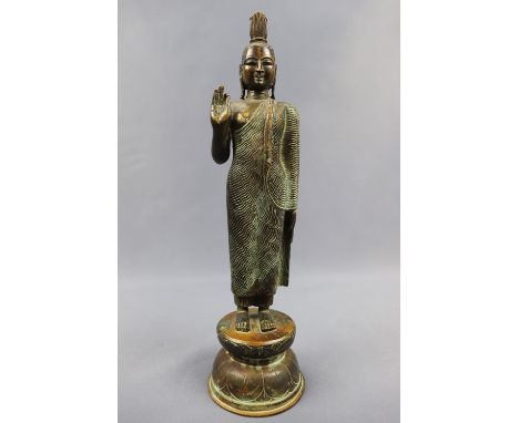 A patinated bronzed statue of a standing Buddha, 20th Century, 32 cm