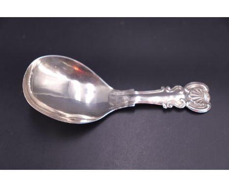 A George IV silver caddy spoon with shell and scroll stem and terminal, John Bettridge, Birmingham, 1823