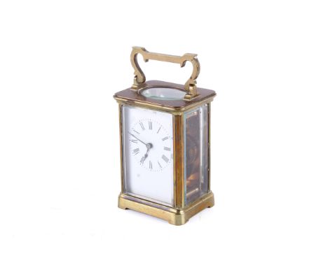 A Edwardian Brass carriage clock. With a porcelain face with Roman numerals,bevelled edge to the glass. H 11cm W 7.5cm.