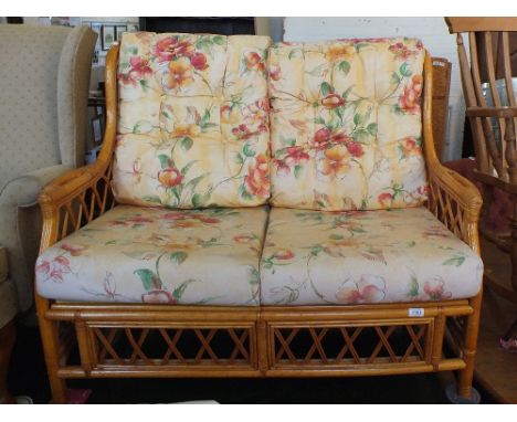 A bamboo upholstered conservatory sofa with cushions