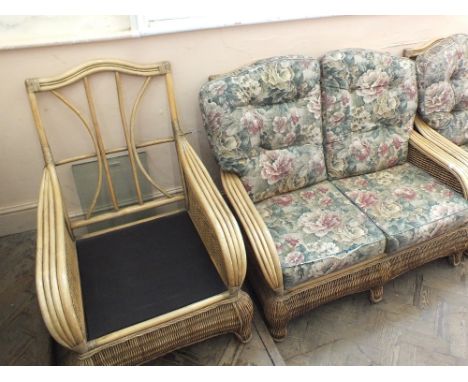 A wicker conservatory suite comprising a two seater sofa and three armchairs (two armchairs missing cushions)