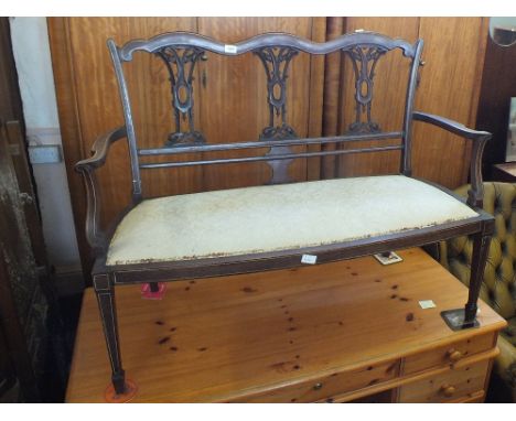 An Edwardian inlaid mahogany salon two seater sofa with cream upholstery