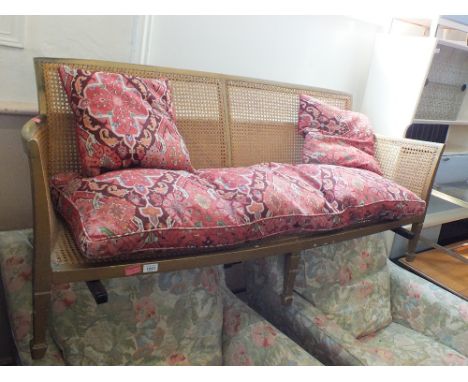 A gold painted rattan two seater sofa