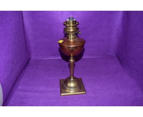 an antique oil burning lamp having copper well with brass fitments by WAS Benson