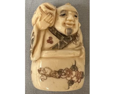A bone netsuke in the form of a dignitary with a carp on his shoulder, 5cm high 