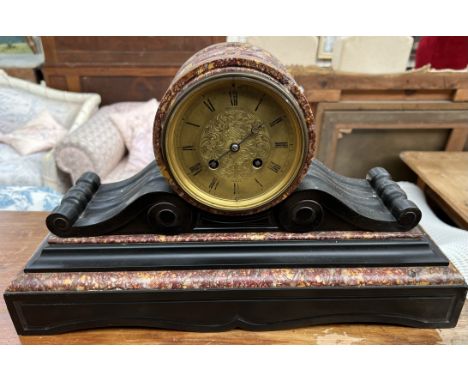 A black slate and marble mantle clock, with a circular form, gilt dial and Roman numerals inscribed West and Son, Dublin, the