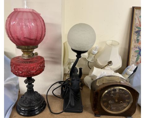 A Victorian oil lamp with a cranberry glass reservoir together with an Art Deco style lamp, a matching chandelier and table l