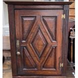 An 18th century hanging corner cupboard, the moulded cornice above a panelled door, 57.