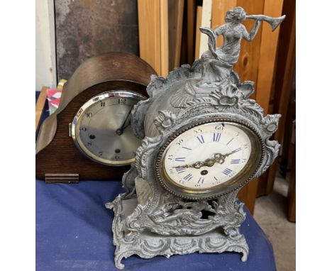 A white metal mantle clock together with another mantle clock and linen