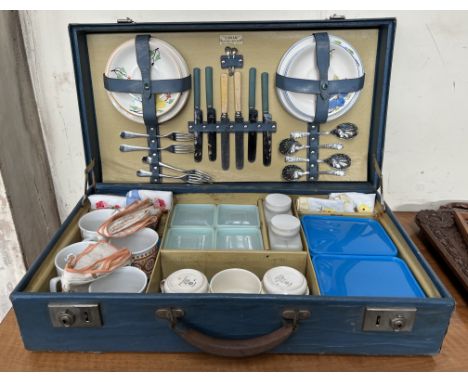 A mid 20th century Sirram picnic suitcase fitted with tea cups and saucers, side plates, cutlery, plastic boxes etc 