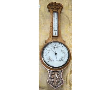 An oak cased aneroid barometer with a mercury thermometer