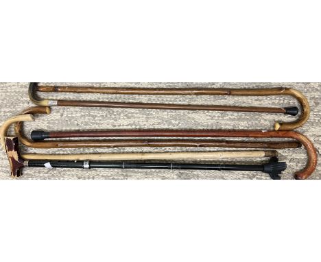 A horn handled walking stick with a silver collar together with a collection of walking sticks