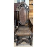A 17th century style oak chair, with a pierced scrolling top with a caned panel,