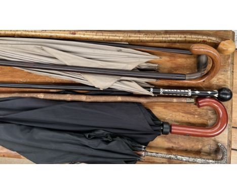 A mother of pearl inlaid walking stick with ball end together with a horn handled walking stick, other walking sticks and umb