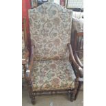 An 18th century style library chair with a camel back and scrolling arms with pad upholstery on