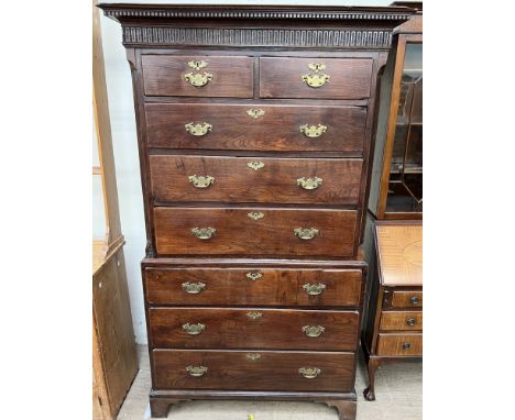 An 18th century oak chest on chest, with a moulded dentil cornice above two short and three long drawers, the base with three