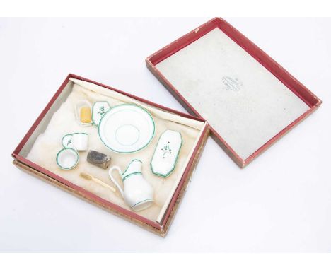 white ground with green lining, comprising jug, basin, two boxes with lid, a jar and cover and bowl, plus soap and a bone too
