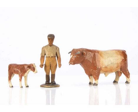 wooden, the brown and cream bull with lead horns and ring through nose —6 1/4in. (16cm.) long, a stable lad in flat cap and h