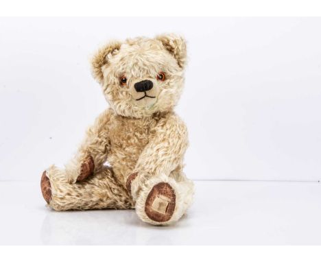with blonde mohair, orange and black plastic eyes, black stitched nose and mouth, swivel head, jointed limbs and painted pads