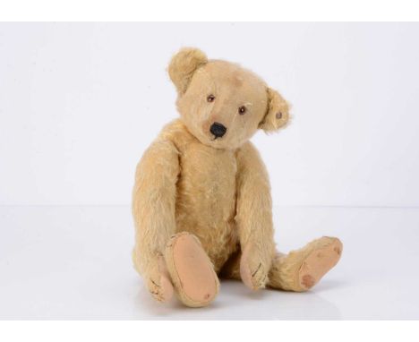 with golden mohair, brown and black glass eyes, black stitched nose and claws, mouth drawn on, swivel head, jointed limbs and