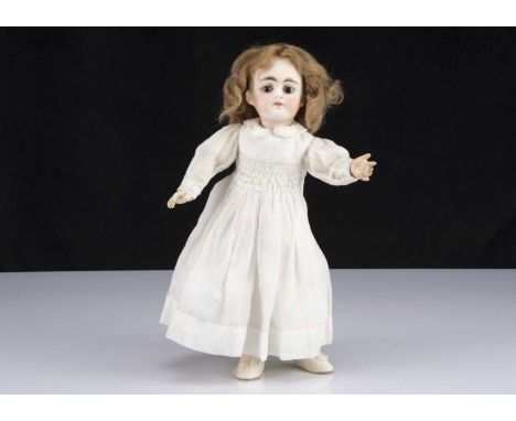 with fixed brown glass eyes, heavy brown brows, closed mouth, light brown mohair wig, jointed composition body, white muslin 