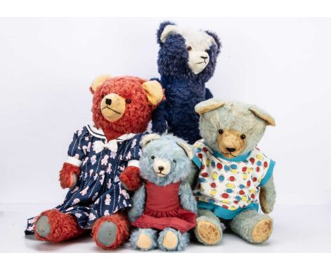 two with red plush, a small light blue bear, a large white with orange and black glass eyes, black stitched nose, mouth and c