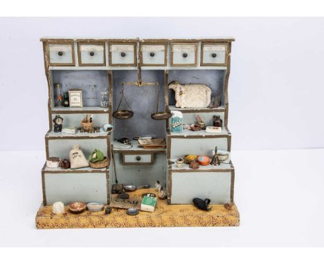 painted pale blue with gold lining, stepped shelves and six drawers with paper labels, various contents and brass scales —14 