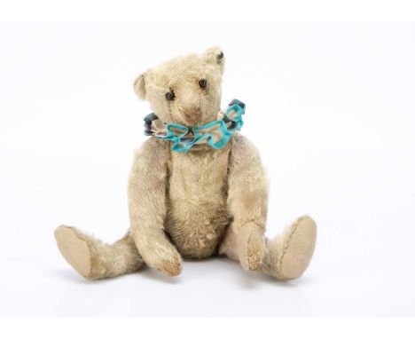 the head of white mohair with black boot button eyes, pronounced clipped muzzle, light brown stitched nose, mouth and claws, 