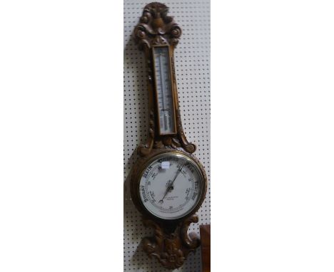 An Aneroid Barometer and Thermometer in carved banjo pattern case.
