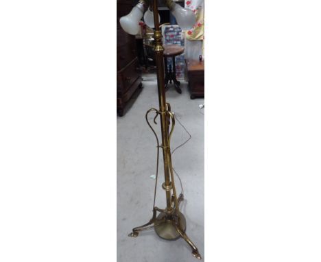 A late Victorian adjustable brass Standard Lamp of Art Nouveau design raised on spade shape feet. 
